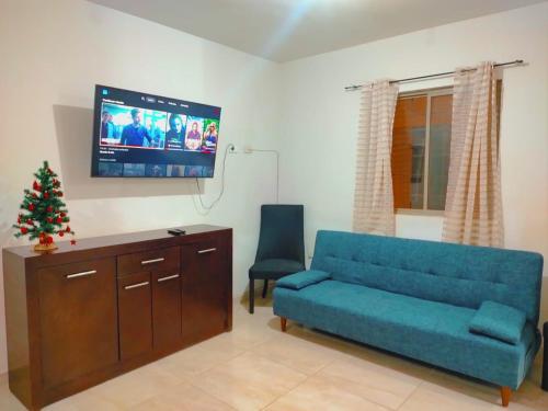 een woonkamer met een blauwe bank en een tv bij Casa Lisboa in Saltillo