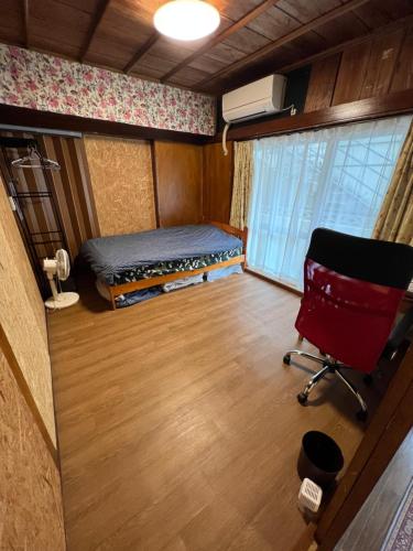 een slaapkamer met een bed en een stoel in een kamer bij ※Japanese Only【villa Ukishima】 in Naha