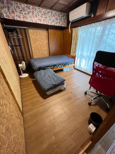 een kamer met 2 bedden, een stoel en een raam bij ※Japanese Only【villa Ukishima】 in Naha