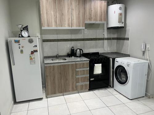 a kitchen with a refrigerator and a washing machine at SJ Apart in Corrientes
