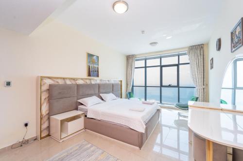 a bedroom with a bed and a large window at Ocean View Luxurious Homes in Ajman 
