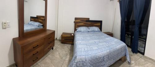 een slaapkamer met een bed, een ladekast en een spiegel bij Adonai in Rincon de Guayabitos