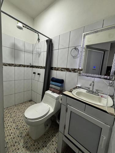 a bathroom with a toilet and a sink at Adonai in Rincon de Guayabitos