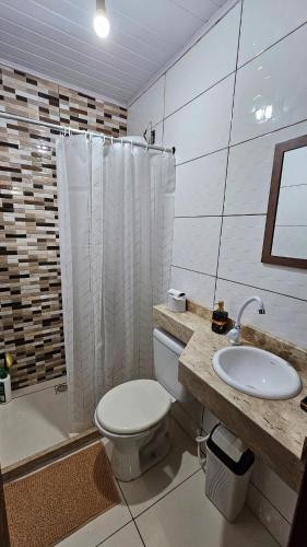 a bathroom with a toilet and a sink and a shower at Atlantic Residence - Guaxindiba in São Francisco de Itabapoana