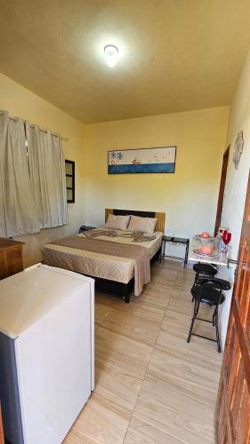 a bedroom with a bed and a table in a room at Atlantic Residence - Guaxindiba in São Francisco de Itabapoana