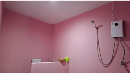 a bathroom with a pink wall with a shower at Nasin House in Ko Bu Bu