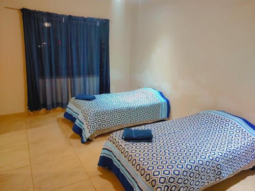 twee eenpersoonsbedden in een kamer met een raam bij Casa Lisboa in Saltillo