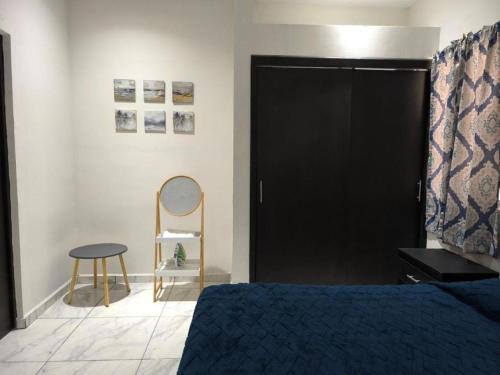 a bedroom with a bed with a black door and a stool at Descanso y Comodidad en Reynosa in Reynosa