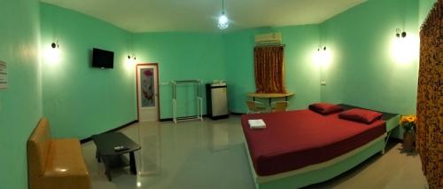 - une chambre verte avec un lit et une télévision dans l'établissement โรงแรมโรแมนติก2, 