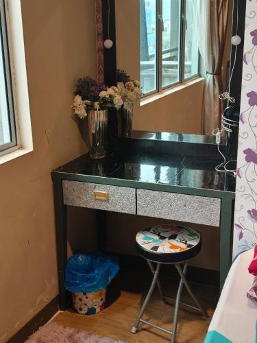a black desk with a mirror and a stool at The Mons inside Tower Regency Hotel and Apartments in Ipoh