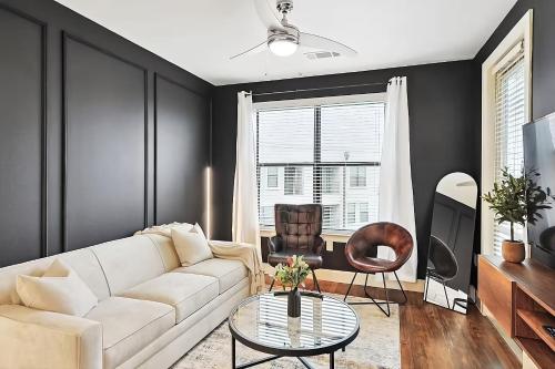 a living room with a white couch and a table at Lux 1B with Pool Near The Star, Legacy West & Toyota in Frisco