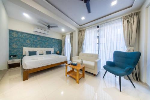 a bedroom with a bed and a blue accent wall at La Bela Casa Suites, Candolim in Candolim