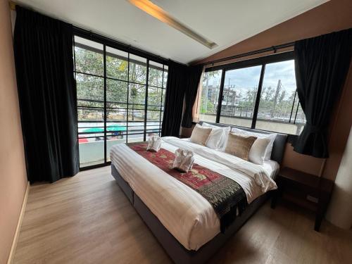 a bedroom with a large bed with large windows at Naiyang Discovery Beach Resort in Nai Yang Beach