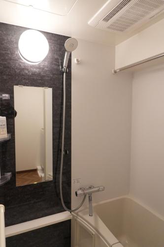 een badkamer met een douche, een bad en een wastafel bij Landmark Sunshine Hotel in Osaka