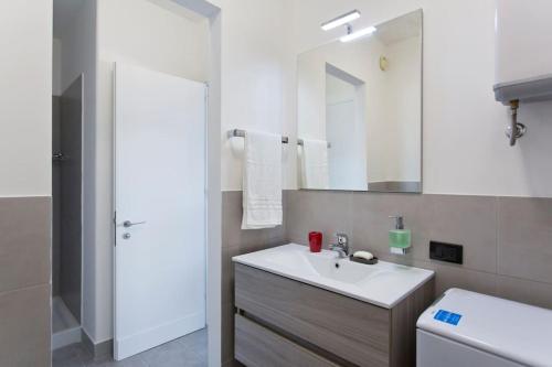 a white bathroom with a sink and a mirror at Mondello Addaura Home Holiday in Mondello