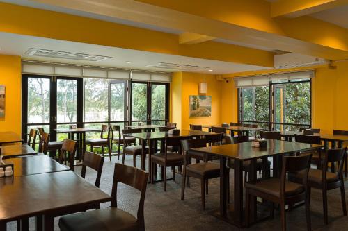 a restaurant with tables and chairs and yellow walls at The Bihai Hua Hin in Hua Hin