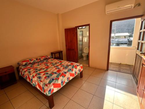 a bedroom with a bed and a window at Hostal Luxury Place in Bahía de Caráquez