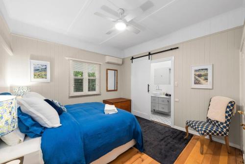 a bedroom with a blue bed and a bathroom at Clark Cottage in Toowoomba