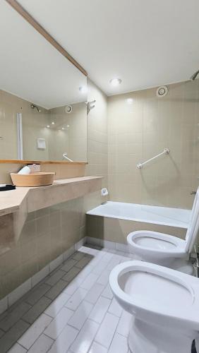 a bathroom with a toilet and a tub and a sink at Amazing View Studio Obelisco in La Porteña