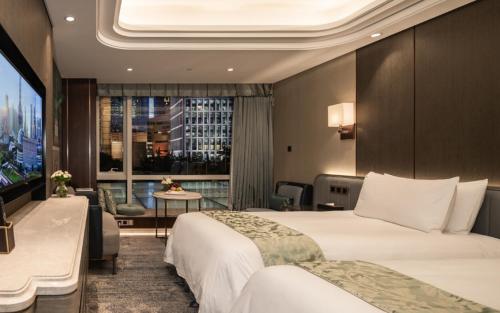 a hotel room with two beds and a large window at Oriental Riverside Bund View Hotel (Shanghai International Convention Center) in Shanghai
