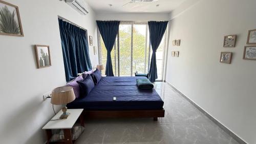 a bedroom with a bed and a large window at Riverfront Grand By GikiJoy in Siolim