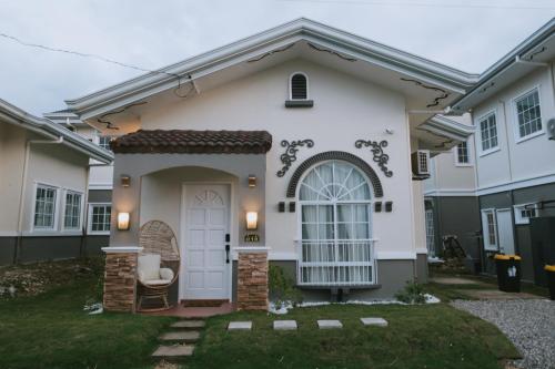 une maison avec une porte blanche et une chaise dans l'établissement Villa Serena, à Dauis