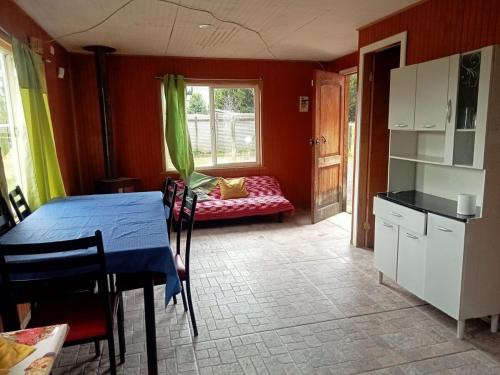 een keuken met een tafel en een bank in een kamer bij Cabañas Loley - a pasos del lago in Puerto Varas
