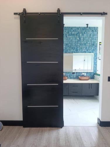a black door in a kitchen with a sink at Residential Finca Celeste in Bijagua
