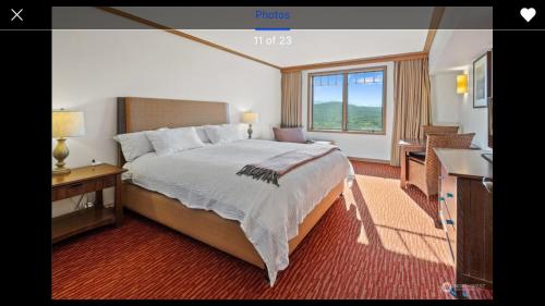 a bedroom with a large bed with a desk and a window at Suncadia Lodge in Cle Elum
