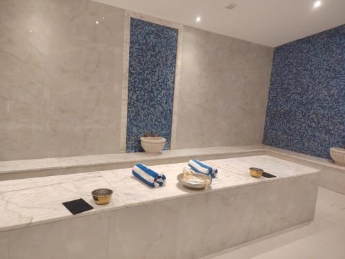 a bathroom with a bath tub with blue tiles at H Luxury Hotel in Wadi Musa