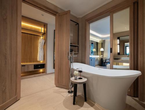 a bathroom with a large tub and a bedroom at HOTEL du LAC SIGNATURE in Hanoi