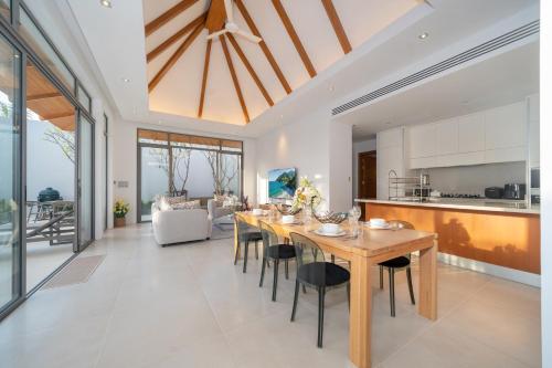 a dining room and kitchen with a table and chairs at Thai-Balinese Pool Villa Anchan Indigo16 in Ban Phru Champa