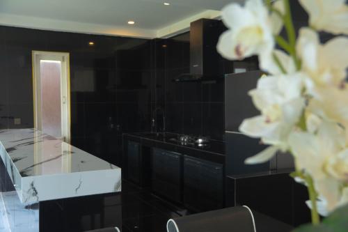a kitchen with black cabinets and white flowers at Phangan Cove Pool Villas in Srithanu