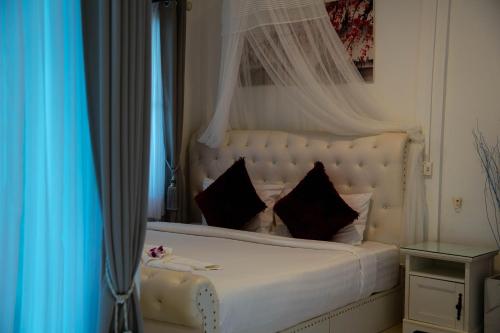 a bedroom with a white bed with black pillows at Phangan Cove Pool Villas in Srithanu
