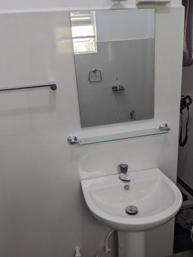 a white bathroom with a sink and a mirror at SR Home stay in Matugama