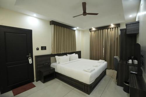 a bedroom with a bed and a black door at Time Square Inn in Erāttupetta