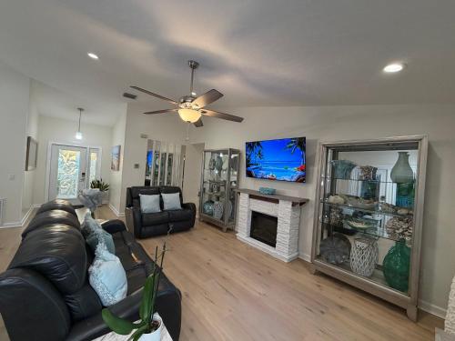 a living room with a leather couch and a tv at Near KSC - Peaceful Spacious Home for 6 - Fully Stocked Kitchen and Coffee Bar in Titusville