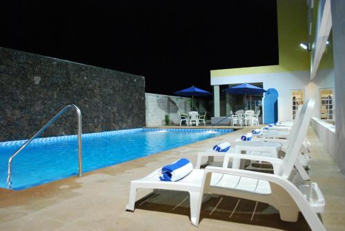 ポサ・リカ・デ・イダルゴにあるRio Vista Inn Business High Class Hotel Poza Ricaの白いラウンジチェア付きのプール、スイミングプール