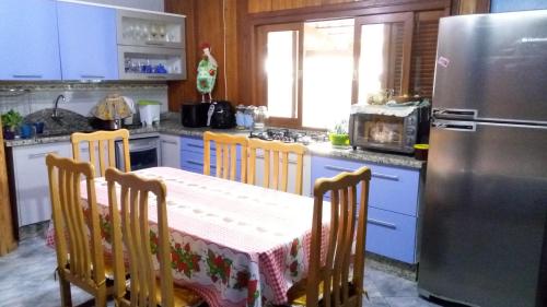 una cucina con tavolo e frigorifero di Magia do Mar Hostel a Florianópolis