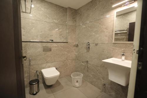 a bathroom with a toilet and a sink at Time Square Inn in Erāttupetta