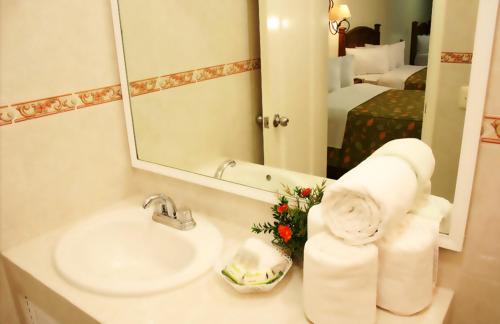 y baño con lavabo y espejo. en Hotel La Vista, en San Martín Texmelucan de Labastida