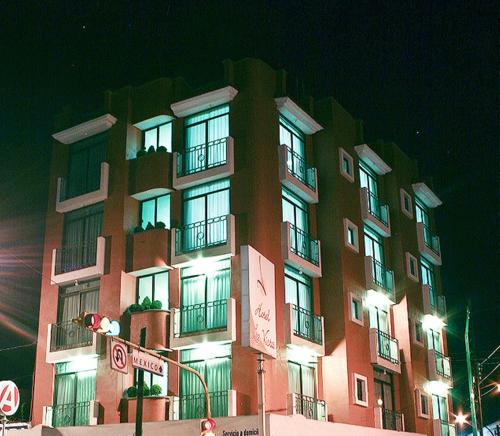 a tall building with windows and balconies at night at Hotel La Vista in San Martín Texmelucan de Labastida