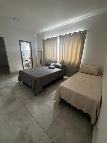une chambre avec deux lits et un miroir dans l'établissement Casa alegre, à Belo Horizonte