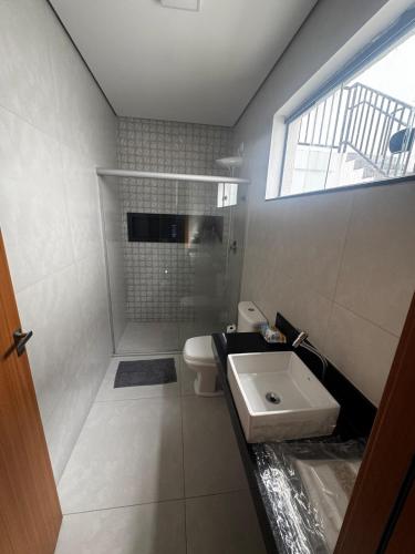 une salle de bain avec un lavabo et des toilettes et une fenêtre dans l'établissement Casa alegre, à Belo Horizonte