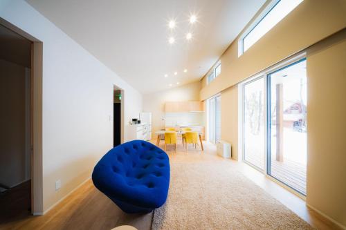 ein Wohnzimmer mit einem blauen Sessel und einem Tisch in der Unterkunft Mimi Hakuba by Jade Villa in Hakuba
