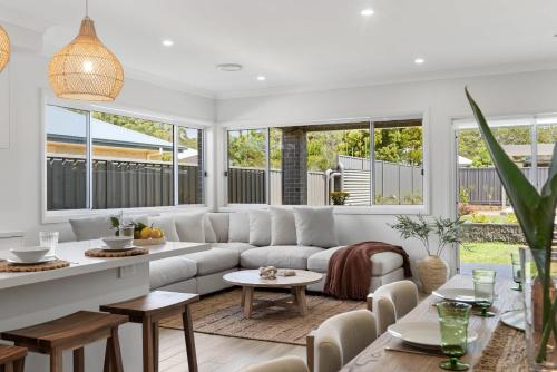 ein Wohnzimmer mit Sofa und Tisch in der Unterkunft Mare Mio Callala Beach Jervis Bay in Callala Beach