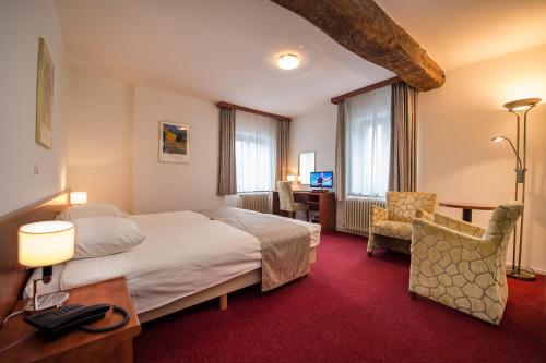 a hotel room with a bed and a desk and chair at Hotel Restaurant in den Hoof in Maastricht