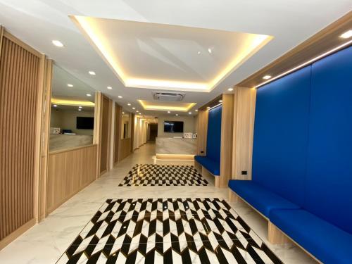 un couloir avec des murs bleus et un sol en damier dans l'établissement Armoni Patong Beach Hotel, à Patong Beach