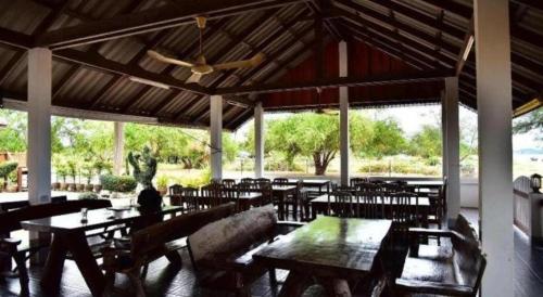 een restaurant met tafels en stoelen en een plafond bij Little Home Beach in Ban Khok Rak