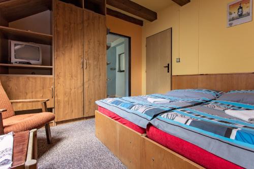 ホルニー・ベチュヴァにあるChata Barborkaのベッドルーム(大型ベッド1台、椅子付)